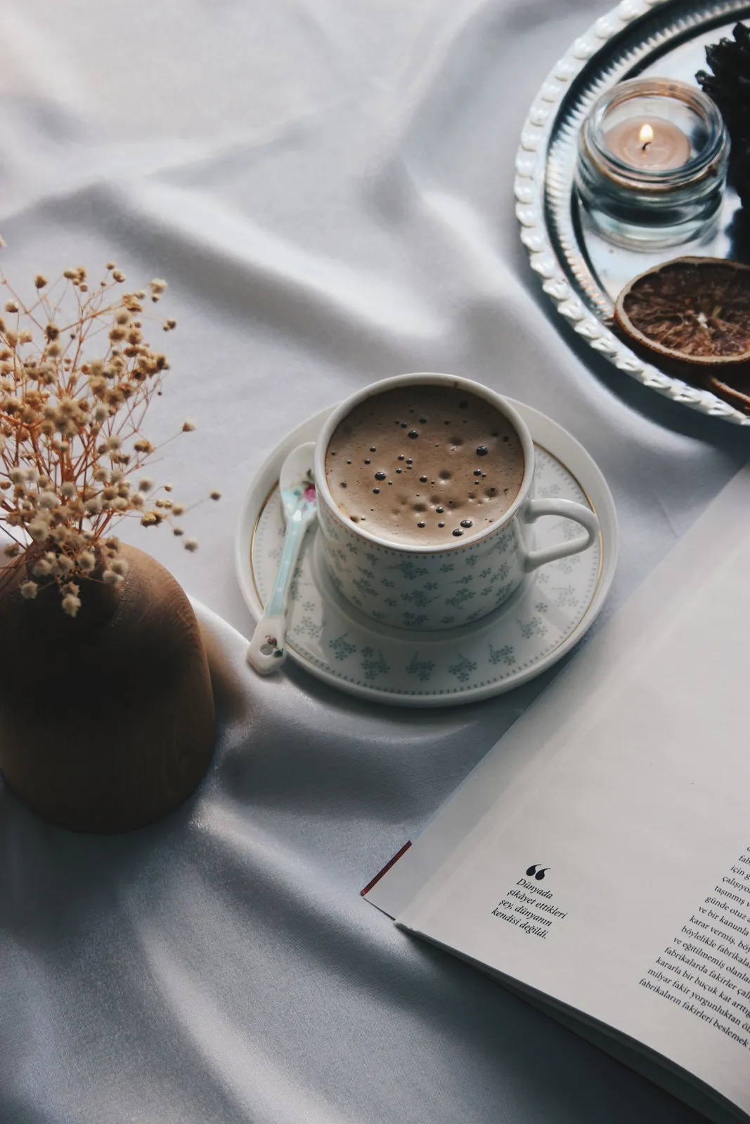 Open book and a cup of coffee on a quiet morning table