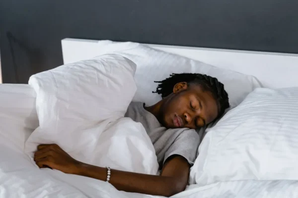 Man sleeping deeply on white bedding
